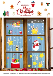 Close-up of Christmas window stickers with snowmen and rabbits on a rustic wooden window