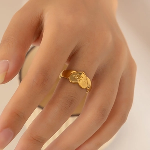 Detailed view of an 18k gold plated stainless steel heart ring with engraved eye pattern