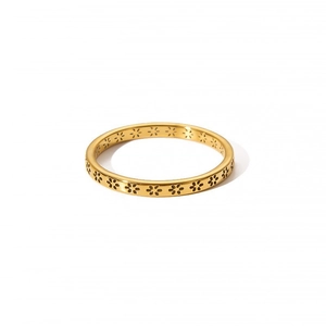 Close-up of golden stainless steel ring featuring hollow flower patterns on white background