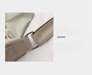 Détail de la large bandoulière en toile et de la boucle en métal gris foncé d'un sac cabas