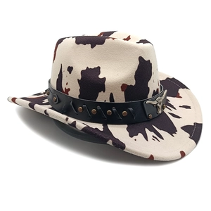 Detail of cow print cowboy hat with studded leather band and bull skull metal buckle