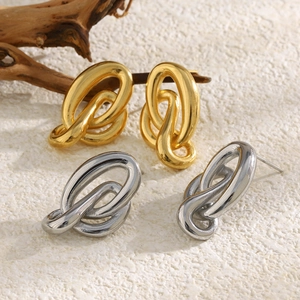 Détail macro de boucles d'oreilles ovales entrelacées en finitions or et argent