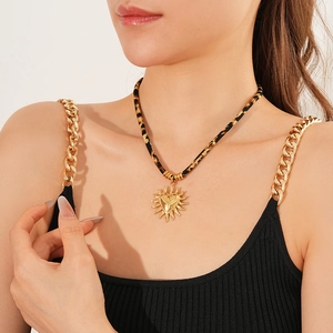 Dettaglio della collana con pendente a cuore sole dorato e cordino leopardato