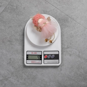 Weight detail of a pink angel ornament on a scale showing 9g for Christmas decor