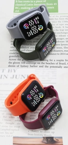 Digital sport watches in gray, olive, orange and burgundy with silicone straps on newspaper