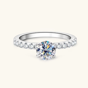 Macro shot of silver moissanite ring showing round center stone and side diamonds