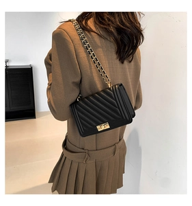 Detail view of the black V-quilted faux leather crossbody bag with gold chain strap