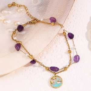 Detail of 18K gold double layer anklet with purple natural stone and dolphin tail charm