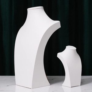 Two white minimalist necklace display busts in small and large sizes on marble