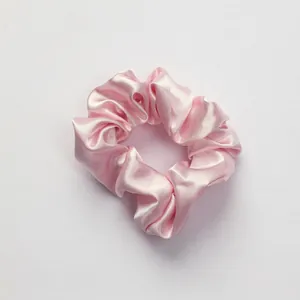 Pink satin scrunchie from the 3-piece sleep set with silky smooth texture and soft pleats