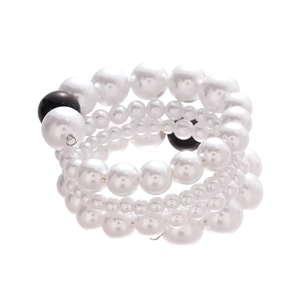 Bracelet multicouche en perles baroques noires et blanches sur fond blanc épuré
