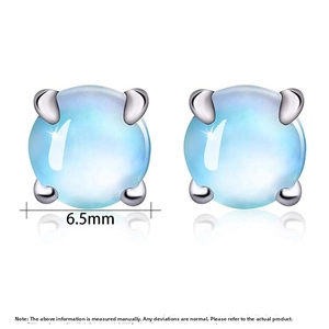 Macro detail of 6.5mm round moonstone earrings with classic four-prong silver setting