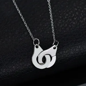 Polished silver stainless steel handcuff necklace on black textured background