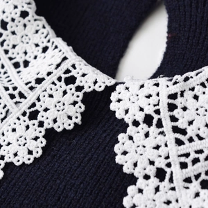 Navy knit sweater featuring a detailed white lace lapel collar with floral patterns