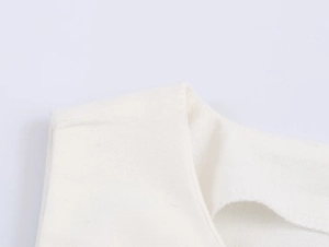Détail de haut sans manches blanc montrant les coutures d'épaule et la texture tissée