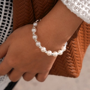 Gros plan d'un bracelet de perles élégant avec entretoises serties de diamants