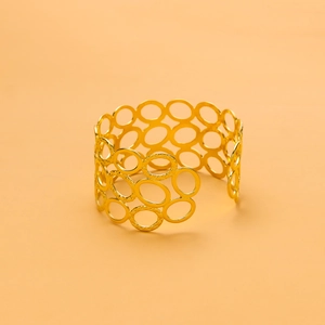 Close-up of elegant gold stainless steel openwork bangle with textured circle links