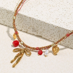Detail of 18K gold plated butterfly pendant with woven cotton cord and pearl beads