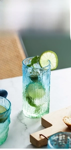 Close-up of ombre blue-green glacier glass with tree bark texture on marble surface