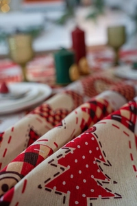 Close-up of linen fabric with red plaid and Christmas tree prints for holiday table decor