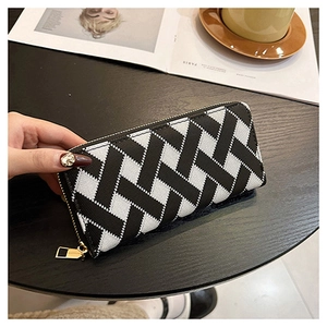 Detailed view of long zipper wallet featuring black and white woven pattern and gold zipper