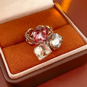 Three-stone square zircon ring with chain-style silver band in an orange velvet jewelry box