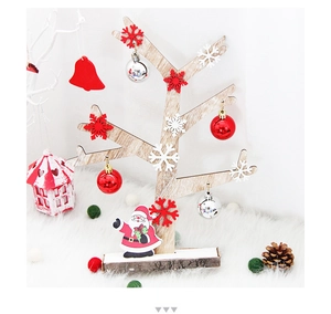 Detail of wooden Christmas tree decor with red ornaments on white plush faux fur background
