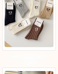 Detail of ribbed cotton socks with cartoon dog embroidery in various earth tone colors