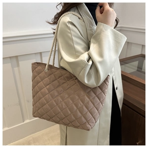 Détail d'un sac cabas en nylon matelassé taupe avec des anses en corde de coton