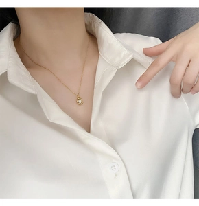 Close-up of a French style natural freshwater pearl necklace on a female model neck