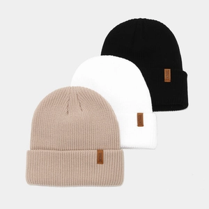 Thick ribbed knit beanies in black, white, and beige with brown leather patches