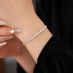 Close-up of elegant silver bracelet with alternating white pearls and zircon stones