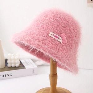 Detailed view of a pink fuzzy bucket hat featuring soft plush texture and a cute bow