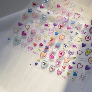 Detail of colorful 3D heart nail stickers with glitter and happy ending text
