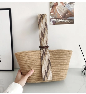 Detail of woven cotton rope handbag with geometric pattern strap and wooden ring charm