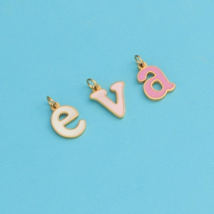 Macro shot of three colorful enamel alphabet charms e, v, and a with golden metal frames