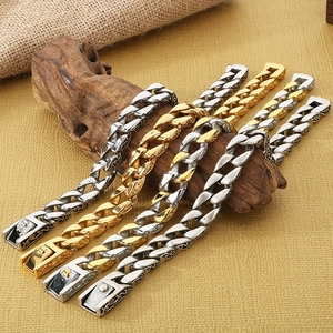 Detail of vintage embossed Cuban link bracelets in silver and gold on a wood block