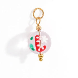 Macro shot of a clear Christmas bead charm with red candy cane and gold metal rings