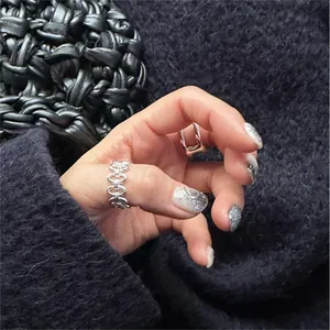 Macro view of a silver-toned hollow chain ring worn on a finger with minimalist style