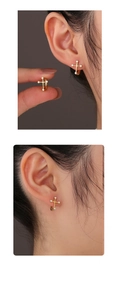 Detailed macro view of S925 silver cross earrings with zircon stones and 14K gold plating