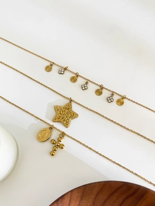 Three-layered gold necklaces with star, cross, and Virgin Mary medal pendants detail
