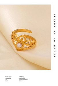 Detail of crown heart ring with pearl on silk background showing vintage golden texture
