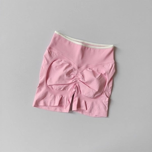 Flat lay of seamless high-waist pink yoga shorts with contrast white trim waist