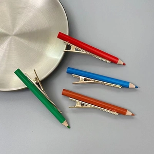 Vue détaillée de quatre barrettes en forme de crayons colorés avec bases dorées