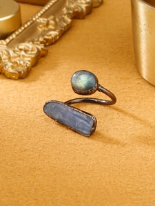 Detail of vintage bronze ring with labradorite and kyanite stones on velvet