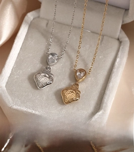 Macro shot of gold and silver strawberry necklaces with drop-shaped zircon in a velvet box