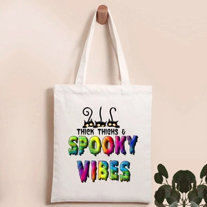 Detail of Halloween pumpkin tote bag featuring Thick Thighs Spooky Vibes text and cats