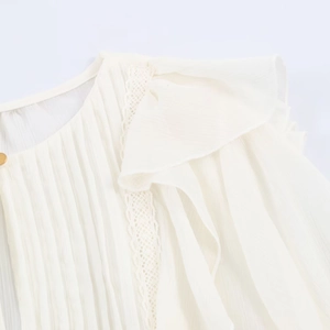 Close-up of white chiffon blouse showing intricate lace edges and pleated ruffles detail
