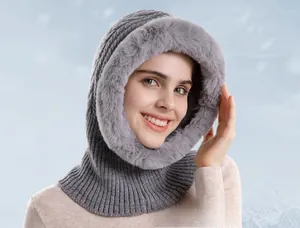 Close-up of grey winter knitted hooded scarf with thick faux fur trim on a model