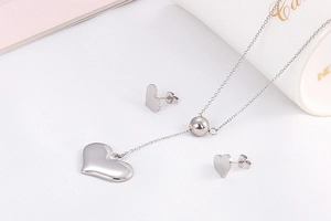 Detailed view of silver stainless steel heart pendant necklace and matching stud earrings